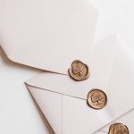 Close-up of elegant white envelopes adorned with classic wax seals, perfect for invitations or correspondence.